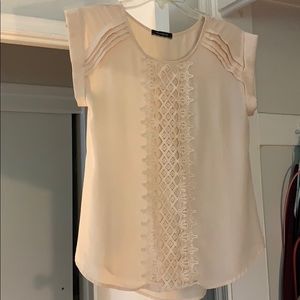 Cream/beige blouse with lace detail.